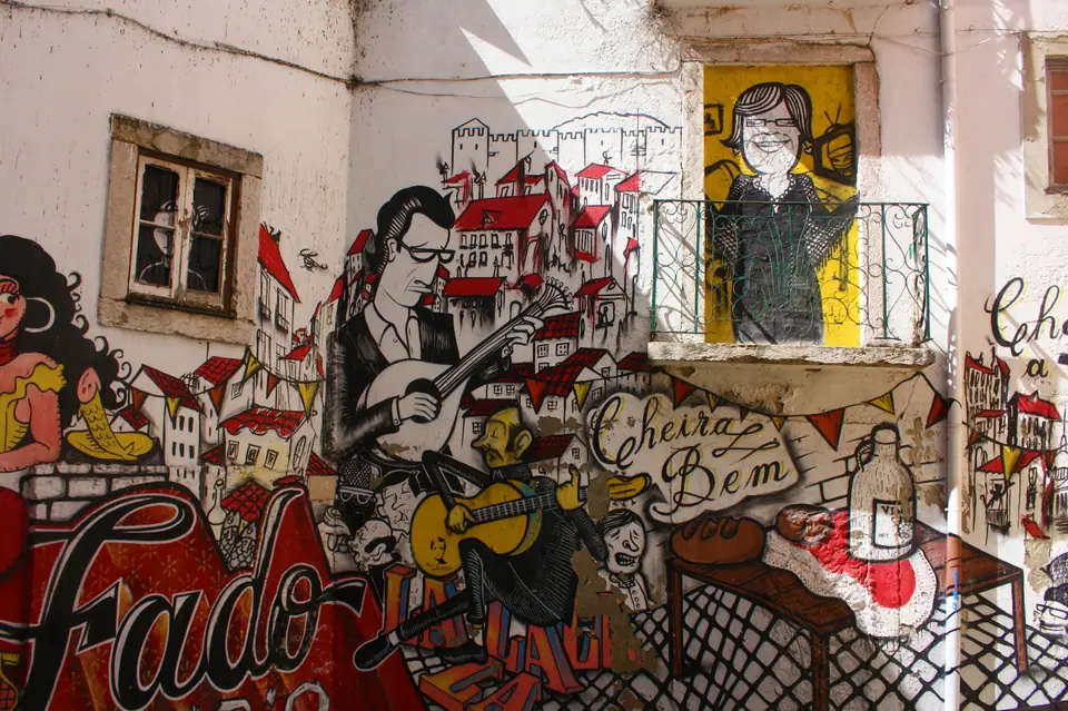 Street mural of fado singers and guitarists on a wall in Lisbon