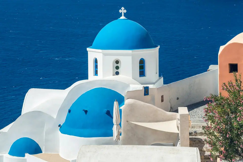 Blue-domed white church above the Aegean Sea in Santorini