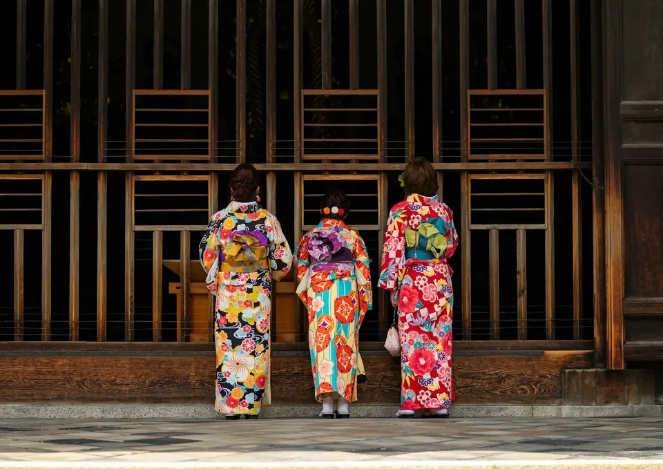 Visitors in kimono at a wooden gate in Kyoto