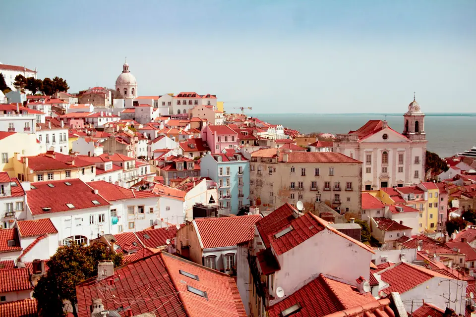 Orange rooftops and white houses of Lisbon above the Tagus river