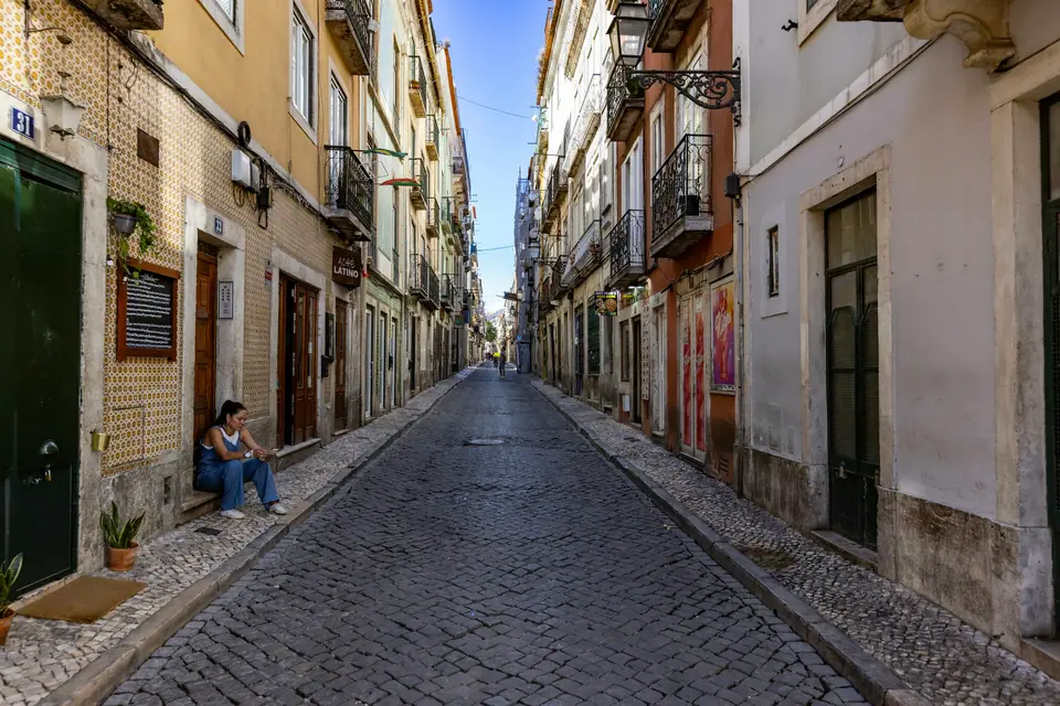 Steep cobbled street lined with pastel houses in Lisbon
