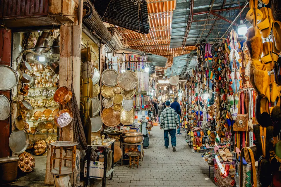 Covered lane in the Marrakech souks lined with lamps and pottery