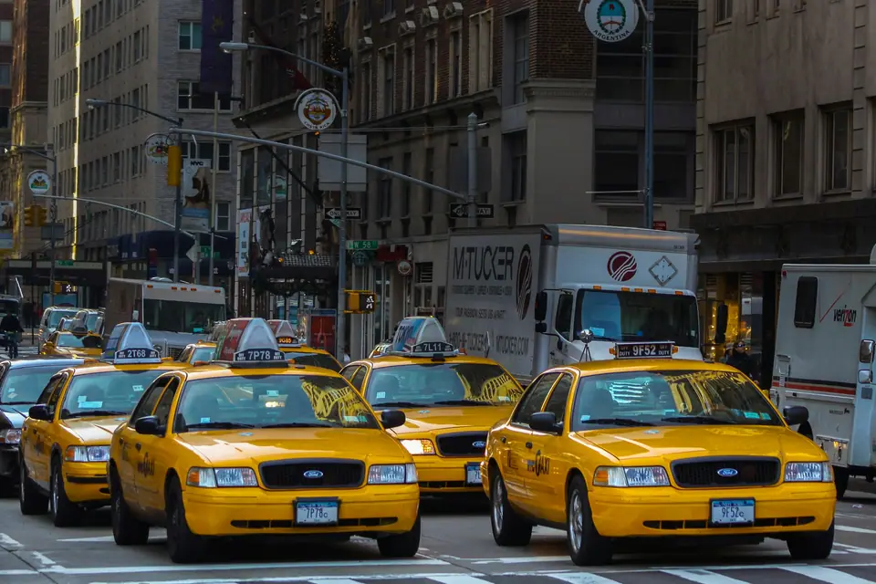 Yellow taxi on a Manhattan street lined with old buildings