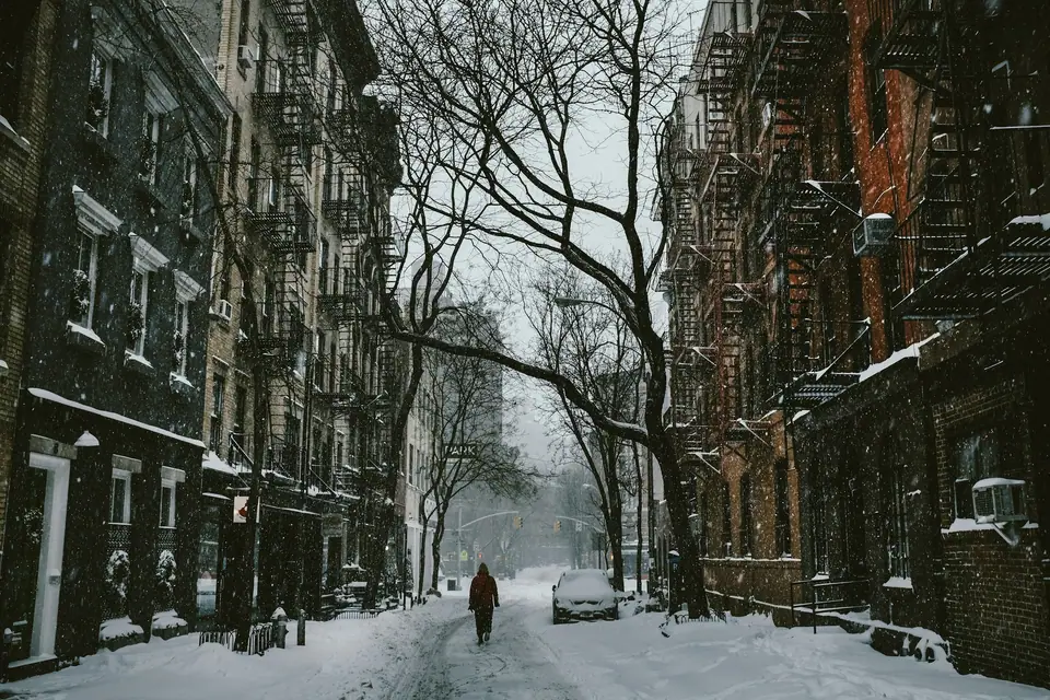 Person walking down a snowy New York street in winter