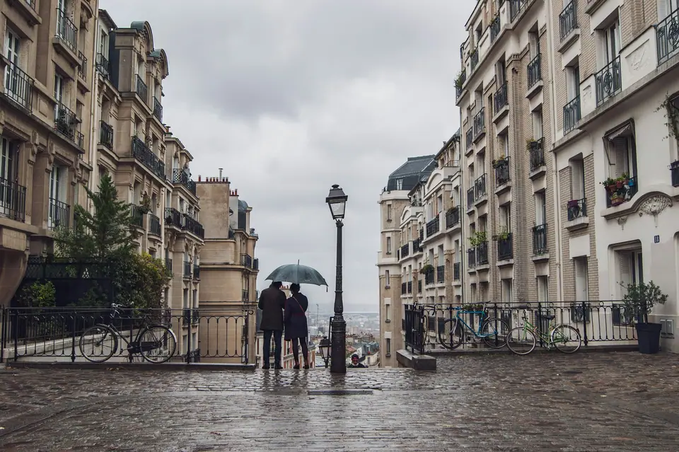People with umbrellas on a wet Paris street